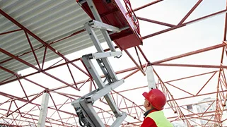 Worker using a scissor lift indoors