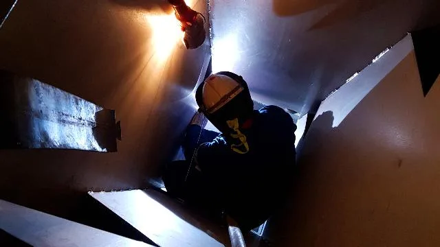 Worker using a light inside a confined space