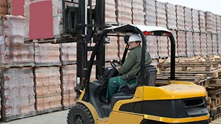 Counterbalanced forklift beside stacked materials