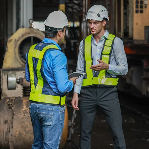 Two workers discussing safety in an industrial workplace