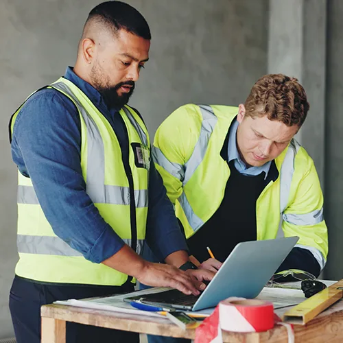 Two workers reviewing safety records at a desk