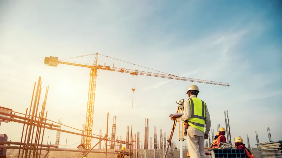 Worker and tower cranes on a construction site